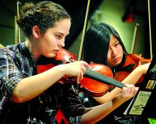 Violinists Sarah Long, left, Williamsport, and Leah Nason, Loyalsock, rehearse with the Region IV/V Orchestra