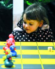 Audrey Earlston, 2, plays with rubber ducks in a ducks race game