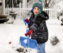 Evan Knowles, 5, tosses a shovelful of snow as he helps his stepmother Jessica Kyttle clear the sidewalk at their Mulberry Street home in Berwick on Monday morning. 