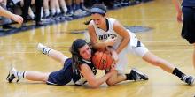 Central Columbia's Kimmy Hollister, left, and Muncy's Crystal Good lock up on the floor for a jump ball going to Muncy during the second quarter of Thursday night's game in Muncy. 