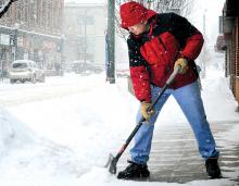 Wu Ni, owner of the J.C. Restaurant, shovels snow in front of his business along West Front Street in Berwick during the snow storm on Thursday. 