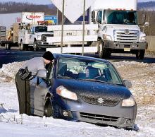 Kari Aluise, 33, of Williamsport, talks to a State Trooper while sitting in the driver’s seat after the 2009 Suzuki she was driving ran off the eastbound lanes of Interstate 80 at the Mifflinville off-ramp on Thursday morning. 