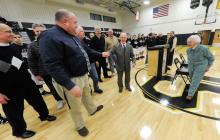 Charles Nesbitt, center, shakes the hand of Southern Columbia High School Principal James Becker as Nesbitt walks away from the podium following his remarks during a ceremony Tuesday evening naming the new gym after Nesbitt before the boys basketball game against Selinsgrove. 