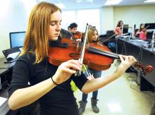 Berwick seventh grader Sierra Miedaner concentrates on some new ideas given to her at the Sringposium at Bloomsburg University Friday. The event is intended for middle and high-school string players who will read through music and play with students their own age.