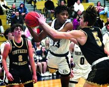 Berwick’s Julian Howie pulls in a defensive rebound between Southern Columbia’s William Swank, left, and Jacob Hoy at Berwick on Wednesday night. Southern won 75-73.