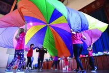 Students from St. Cyril Preschool and Kindergarten red team move under the parachute while doing activities in the school’s gym Wednesday during a pay to play fundraiser for the Montour Area Recreation Commission. 