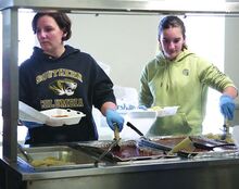 On Friday evening, Jessica Webster (left) and Jacey Webster plate food at Catawissa Hose Company’s fish fry.