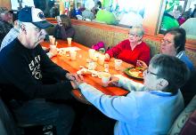 Fire victim Larry Poust, left, holds his mother-in-law Elaine Morgan's hand as he is overwhelmed by support at a breakfast benefit held for him and fellow Eighth Street fire victims, the Zubler family, Saturday morning at Applebee's in Bloomsburg.