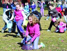 Hannah Johnson, 10, tosses an egg in her basket during the Bloomsburg American Legion Easter Egg hunt Saturday at Town Park in Bloomsburg.
