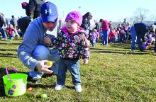 Drew Harmon helps his daughter Malania, 1, pick up eggs at the Espy Fire Company hunt Saturday morning.