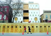  A wooden pedestrian walkway is built Monday in front of Matt Zoppetti's property along Main Street in Bloomsburg. The building that is replacing the former First Federal Savings and Loan of Hazleton will have commercial property on the first floor with student housing above. 