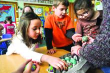 St. Cyril kindergarten students Ava Bulger, Gavin Holcombe and Gina Emery get a closeup look as some of the Pysanky Eggs. 