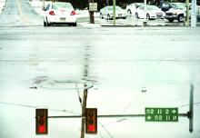 The traffic signals at the intersection of Tenny Street and Route 11 in Scott Township are reflected in a huge puddle Tuesday.