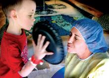 Trenton Dawson, 7, of Covington, slaps a whipped-cream pie into the face of Dr. Jessica Nelson during the Janet Weis Children’s Hospital “Pie Your Doctor” event on Friday afternoon.