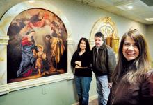 Danville artist Ana Truqui Arnabar, right, stands by one of the panels of her triptych in St. Hubert’s Chapel in St. Joseph Church, Danville, on Friday. She is one of the artists participating in the 37th annual Spring Thaw art show and sale to be held at Hawkins Chevrolet showroom, 435 Mill Street in Danville, on Thursday, April 3, through Saturday, April 5. Behind her are Spring Thaw founders and organizers Mary Fallon Shultz and Ken Conner.