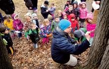Chris Hall prepares to tap a maple tree on the grounds of Trinity United Methodist Church in Mahoning Township duirng a visit with the Trinity Child Care children. Hall and Gavin Noble, not in photo, demonstrated and explained the maple sugaring process to the youngsters.
