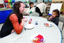Press Enterprise/Rebecca Villagracia Danville Headstart teacher Dawn Gouty, left, and student Neida Delgado, right, laugh about an activity with paint in Ms. Heather Crumb’s class on Thursday at Danville Headstart. Enrollment might be reduced next fall to increase staff pay. 