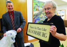 Bloomsburg High School Graduate of Distinction inductee Gloria Marks VanCleave holds up a sign which was presented to her by members of her 1947 class during Friday evening's ceremony at the school while Superintendent Cosmas Curry watches. 