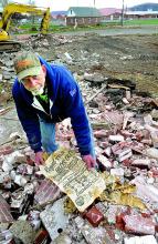 Bloomsburg town worker Carl Barratt, on Thursday, displays a Philadelphia Inquirer from October 20, 1957 that had been crumpled into a glass jar embedded in the concrete steps of the former Dick Fornwald home at 920 West Main St.
