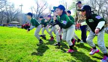 Little League players run from right field to the pitching mound after being introduced during the Bloomsburg Little League opening ceremony Saturday at Town Park.