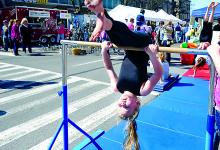 Gabby Hashagen, 6, performs on a bar at the Scorpions Gymnastics stand at the Renaissance Jamboree.
