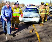 Driver George E. Laurenson, left, 82, of Hemlock Township, walks around his 1998 Buick, after climbing out the passenger side, following a two-car accident along Route 11 in Scott Township on Tuesday morning. 