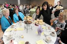Tina Clark, top right, places a plate of sandwiches on the stand in the center of the table Sunday afternoon during Balzano's Spring Tea & Craft Show at Rolling Pines Golf Course & Banquet Facility. 