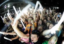 Concert-goers swing light sticks and wave their arms in the air as the group Krewella takes the stage Wednesday night during the show at the Nelson Field House on the upper campus of Bloomsburg University.