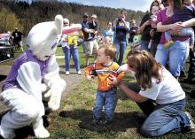 Stetson Brobst, 20 months, of Mifflin Township, isn’t sure just how close he should venture to the Easter Bunny during the Main Township Volunteer Fire Company Easter egg hunt on Sunday. Encouraging the lad is his grandmother Joyce Brobst.