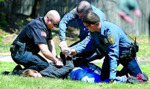 Police arrest a block party reveler on Saturday afternoon.