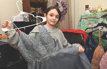 Chloe Birt displays her favorite prom dress she has collected while starting to set up a prom dress closet for girls to find a dress. 