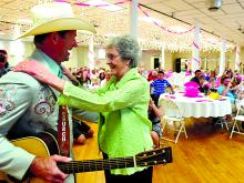 Country music recording artist David Church, left, is greeted with a hug from admirer Arlene Kile after singing her happy birthday Sunday during a party in her honor at Caldwell Consistory in Bloomsburg. Kile will turn 90 on May 18th.