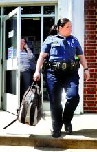 Bloomsburg Police Officer Melanie Readler carries out a backpack left in the lobby of the Bloomsburg Post Office on Tuesday morning.