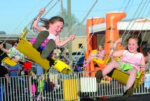 Emma Johns, 4, left, and her sister Eva Johns, 7, of Bloomsburg ride on the swings at the Bloomsburg Fire Department Carnival Wednesday evening behind the station at 911 Market Street. The carnival runs through Saturday and features food, rides, games and music. 