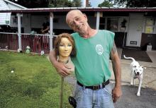 Butch Jones stands, on Wednesday, in front of his Orange Street home in Berwick with the mannequin head he mounted on a broom stick in his front yard. Jones called the head a “bachelor’s roommate” and added that “she keeps me company.”