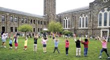 Teacher Betsy Finn, center, leads St. Cyril Academy kindergarten and preschool students in warmup exercises before the start of the annual field day at the Danville parochial school on Wednesday morning. (Press Enterprise/Bill Hughes)