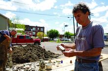 Robert Lee holds up a glass bottle found while digging at the site of an 1840s outhouse on Friday on the parking lot of Lower Mulberry St and Jacobs Alley in Danville. Some glass bottles used to hold medicine. 