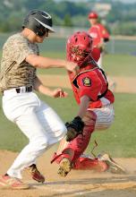 Danville catcher Cody Keefer, right, swings around with the tag, missing West Snyder's Chad Eberle, who scores on a bunt in the fourth inning of Tuesday evening's American Legion game in Danville. 