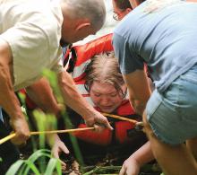 Rescue personnel from the Lightstreet Fire Company lift and pull a swimmer out of Fishing Creek in Scott Township just upstream from the Back Branch Road bridge Monday evening. The woman spent a hour in the water and was unable to get out. 