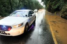 A Montour Township Police cruiser blocks the southbound lane of Route 42 in the Narrows as traffic uses the northbound lane to pass through a flooded section of the roadway Thursday evening. Montour Township Fire department members also assisted at the site, directing traffic. 