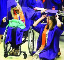 Danville High School graduate Juliana Wilkham, gets helping hand with her mortar board from fellow classmate Alexandria Allen, left, prior to the start of the school's commencement ceremony Friday night at the Whitey McCloskey Center Gymnasium.