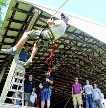 Espy fire captain Doug Kashner makes his way down a zip line in the fire company parking lot Sunday morning. Firefighters used the day to practice rope rescue skills, including the zip line.
