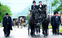 A procession led by a horse-drawn hearse makes its way up Market Street in Berwick after a funeral service re-enactment at First United Methodist Church Sunday.