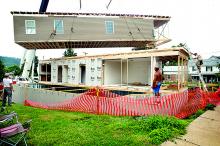 A crane is used to move a section of Larry and Karen Poust’s new modular house into place on East Eighth Street in Bloomsburg on Wednesday. 