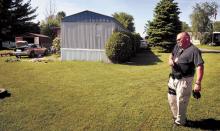 Locust Township Police Chief Allen Breach talks on his phone, on Sunday, outside the Country Acres Trailer Park home in Numidia that Paul and Stephanie Cummings shared with their four children. Paul Cummings, 33, is in jail charged with operating a meth lab. Stephanie Cummings was released with the four children.