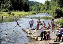 Bathers cool off in the waters of Fishing Creek as it flows by Frank W. Kocher Memorial Park near Lightstreet on Sunday afternoon.