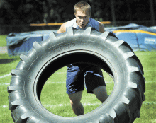 Northwest High School lineman Cody Hart concentrates on lifting and pushing a tractor tire for 30 yards during the Lineman Challenge competition Saturday at Northwest High School, Shickshinny