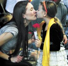Holding her diploma and a red carnation, St. Columba School pre-K grad Saleah Shannon gives her mom, Samantha Shannon, a kiss at the conclusion of the graduation exercise at the Bloomsburg parochial school on Friday morning, Partially hidden is Saleah’s dad, Jonathan Shannon.
