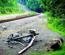 A Canadian Pacific Railway crossing standard lies mangled on the ground on Tuesday following an early-morning one-vehicle accident on River Road in Nescopeck Township. Police say a red Mitsubishi Eclipse crashed into the standard and three men were transported to the hospital. 