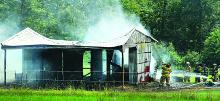 Firefighters work to put out a blaze in a barn filled with hay along Grange Hall Road near Sweet Valley Thursday afternoon.
